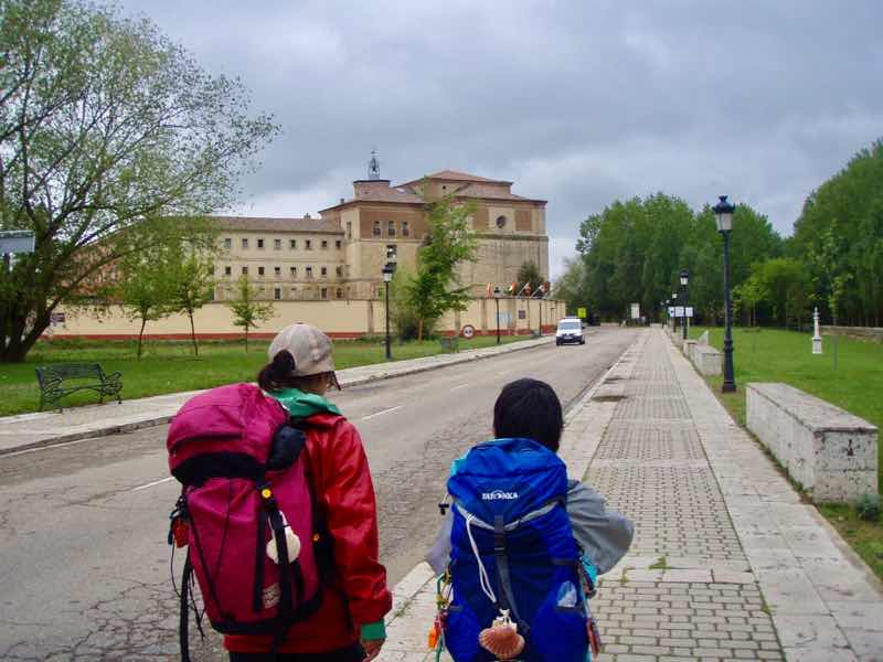 512 カルサディージャ・デ・ラ・クエッサ カミーノ　17km一本道　1.2後ろ姿　左手教会